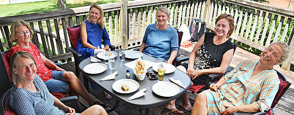Damen50 sitzen auf Terrasse am Tisch